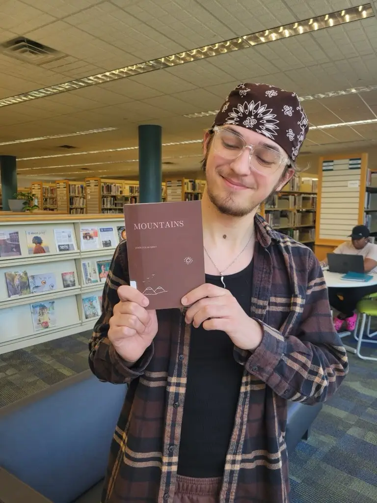 Author John Colacarro holding his book Mountains