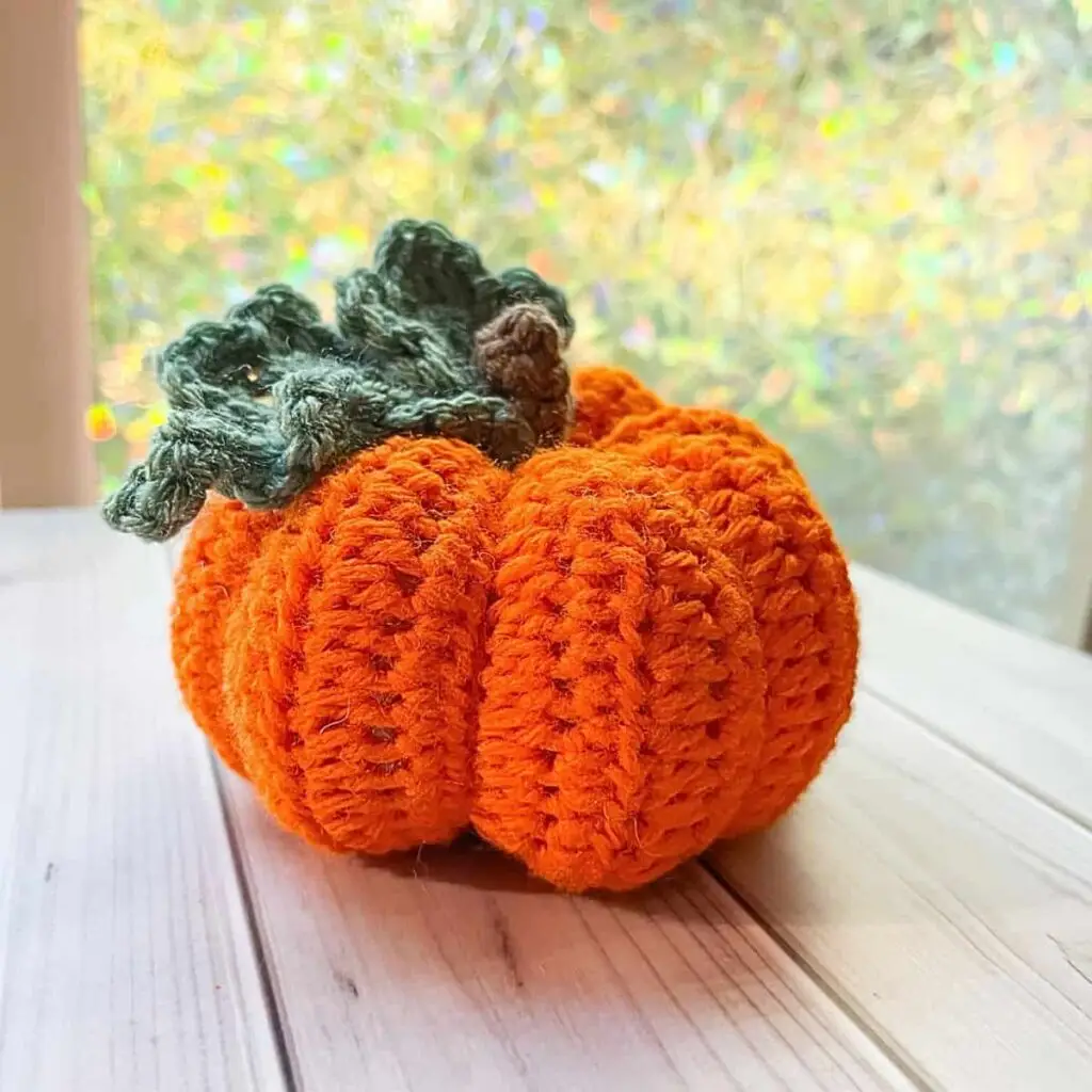 orange crochet pumpkin sitting on a table