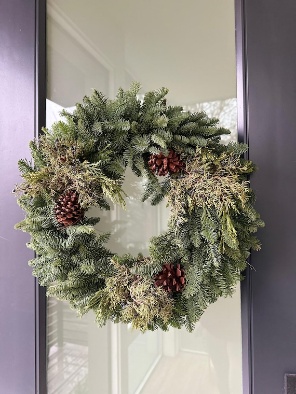 wreath made of evergreen boughs hanging on a door